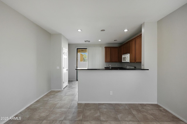 kitchen featuring light tile patterned floors and kitchen peninsula