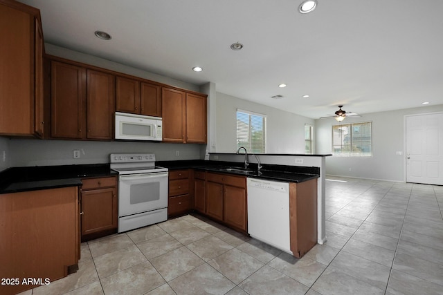 kitchen with ceiling fan, kitchen peninsula, sink, white appliances, and light tile patterned floors