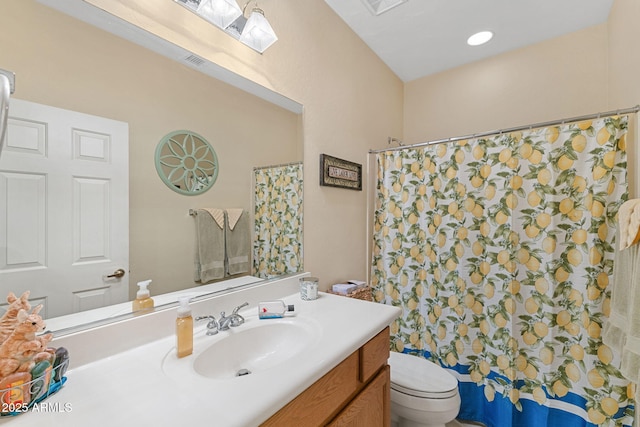 bathroom with toilet, vanity, a skylight, and walk in shower