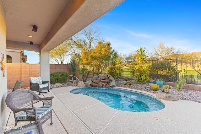 view of swimming pool featuring pool water feature and a patio