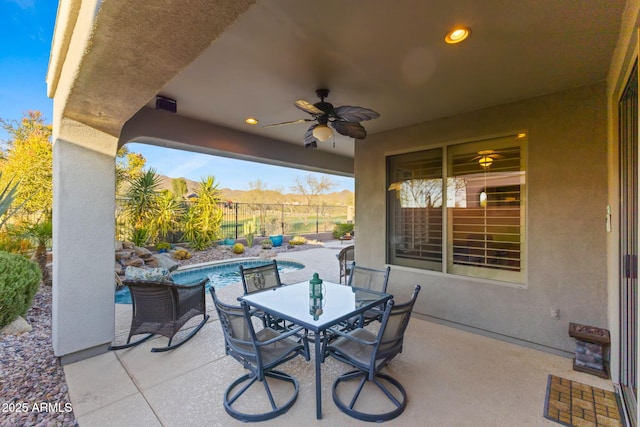 view of patio / terrace with ceiling fan and a fenced in pool