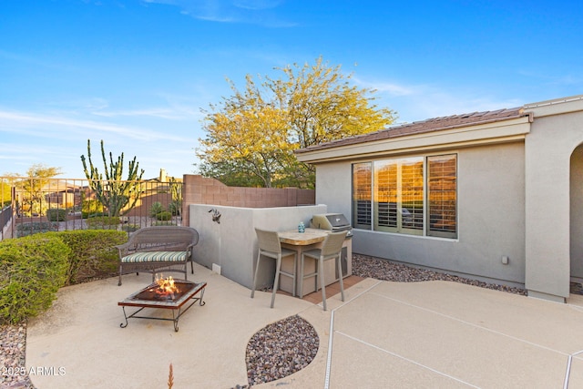 view of patio with an outdoor fire pit and exterior kitchen