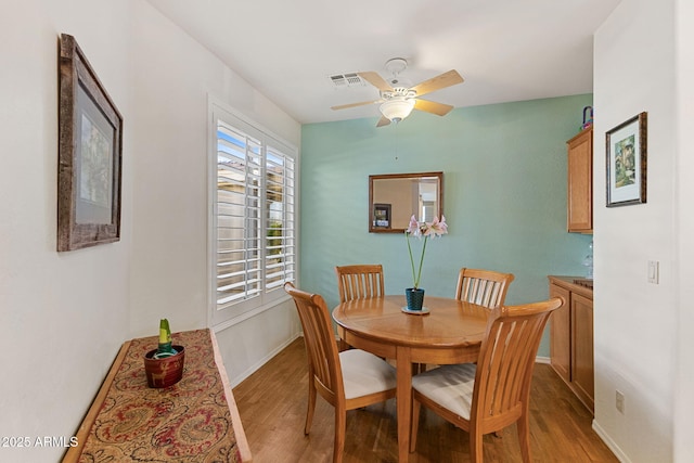 dining room with light wood-type flooring and ceiling fan