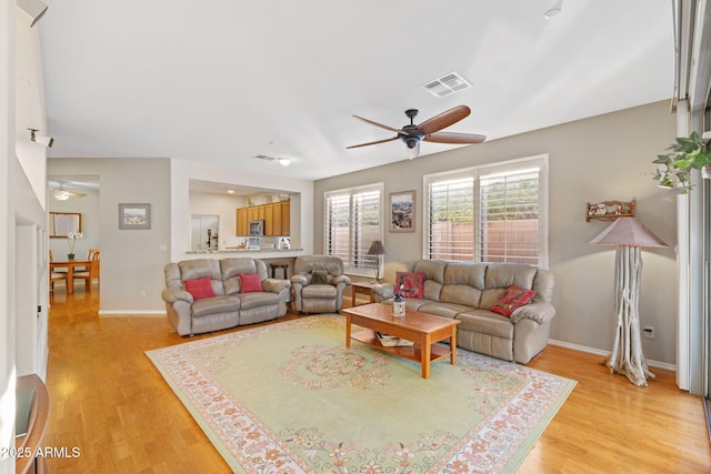 living room with ceiling fan and light hardwood / wood-style flooring