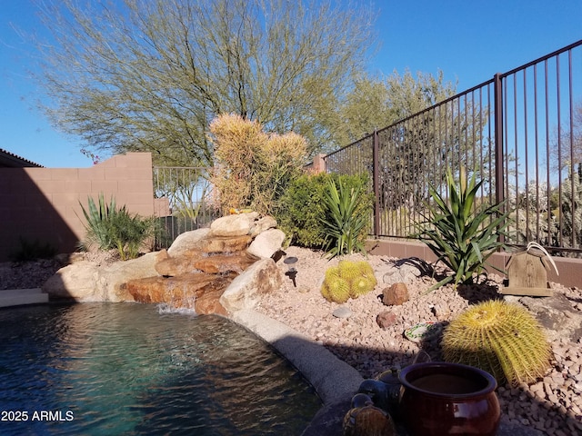 view of yard with a swimming pool and pool water feature