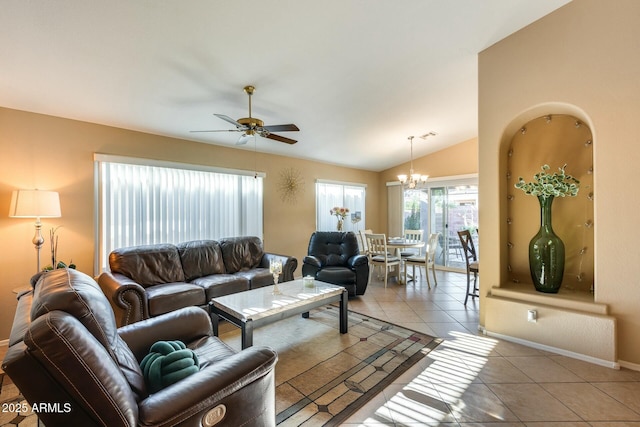 living area with vaulted ceiling, ceiling fan with notable chandelier, light tile patterned flooring, and baseboards