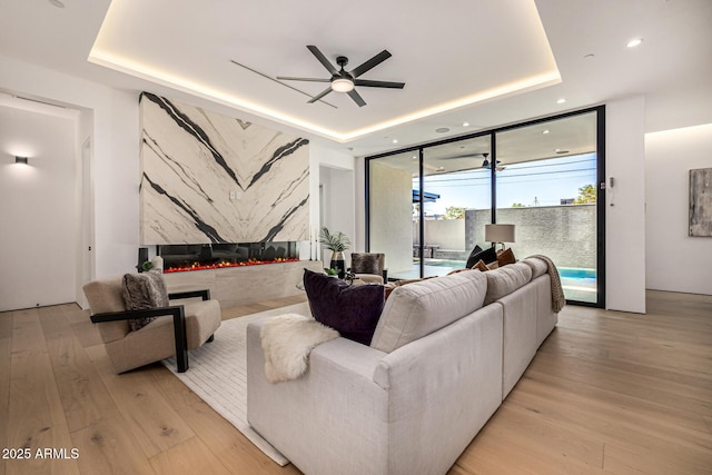 8038 E Clarendon Ave, Scottsdale, AZ 85251 - living area with a tray ceiling, floor to ceiling windows, light wood-style floors, recessed lighting, and ceiling fan