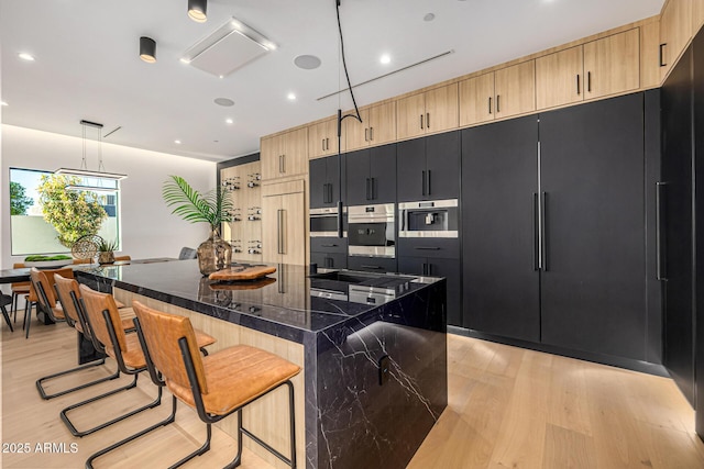 8038 E Clarendon Ave, Scottsdale, AZ 85251 - kitchen featuring light brown cabinetry, light wood-type flooring, a breakfast bar area, and recessed lighting