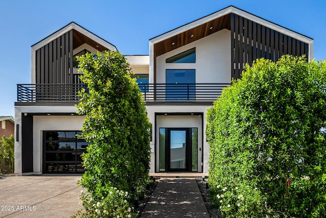 8038 E Clarendon Ave, Scottsdale, AZ 85251 - modern home featuring a balcony, board and batten siding, stucco siding, concrete driveway, and a garage