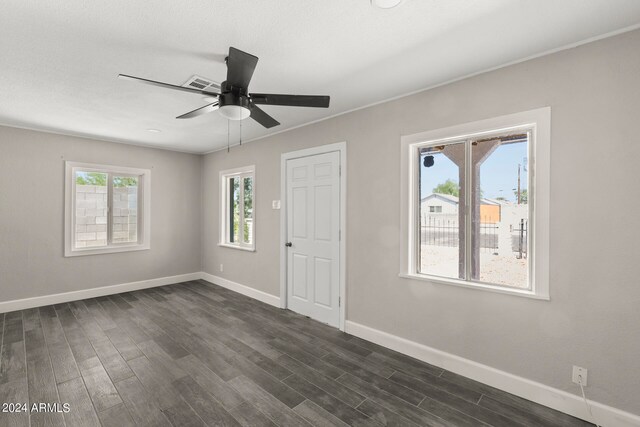 empty room with dark hardwood / wood-style flooring and ceiling fan