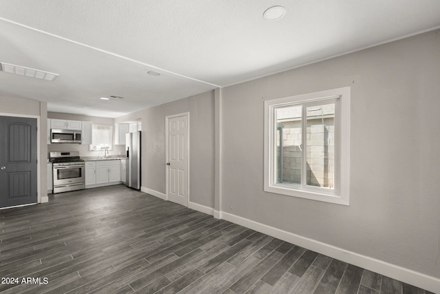 unfurnished living room with dark wood-type flooring and sink