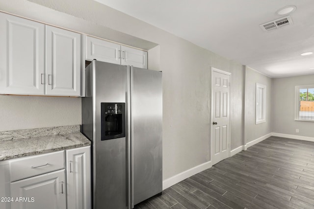 kitchen with stainless steel fridge, light stone countertops, white cabinets, and dark hardwood / wood-style floors