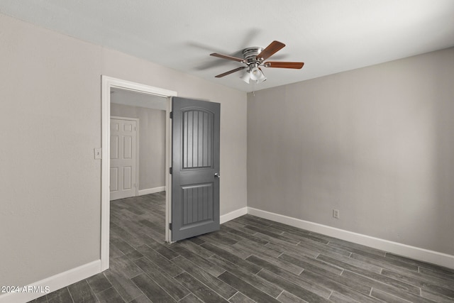 empty room featuring dark wood-type flooring and ceiling fan