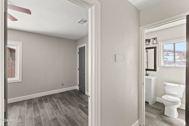 bathroom featuring toilet, hardwood / wood-style flooring, and ceiling fan