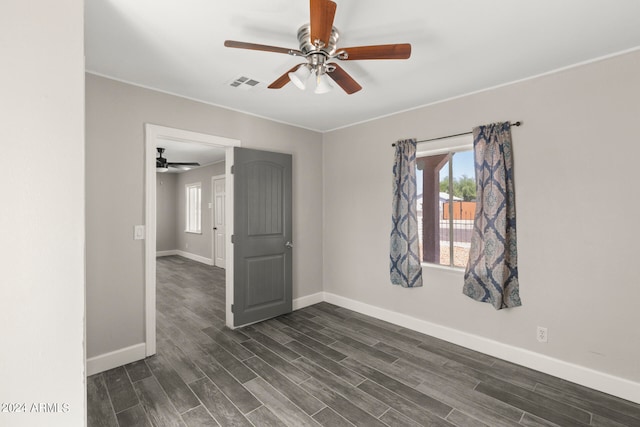 unfurnished room featuring dark wood-type flooring and ceiling fan