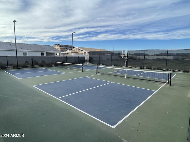 view of tennis court featuring basketball hoop