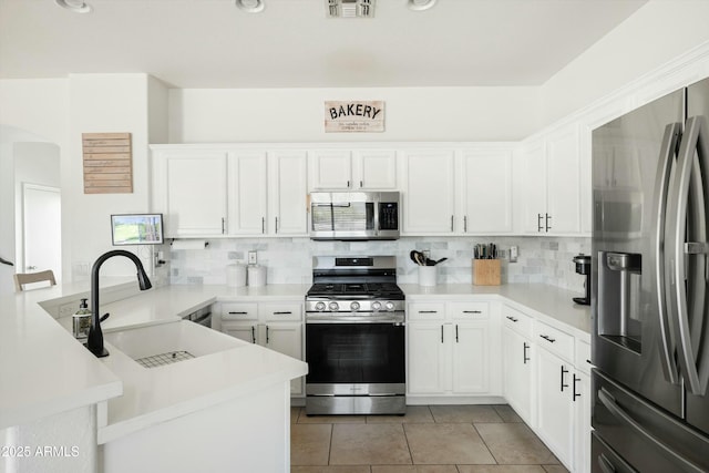 12209 W Washington St, Avondale, AZ 85323 - kitchen featuring appliances with stainless steel finishes, a peninsula, a sink, and tasteful backsplash