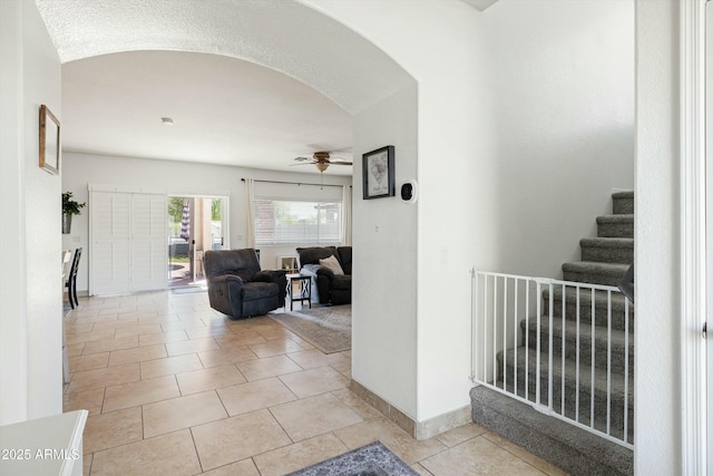 12209 W Washington St, Avondale, AZ 85323 - hall featuring arched walkways, stairs, light tile patterned floors, and baseboards