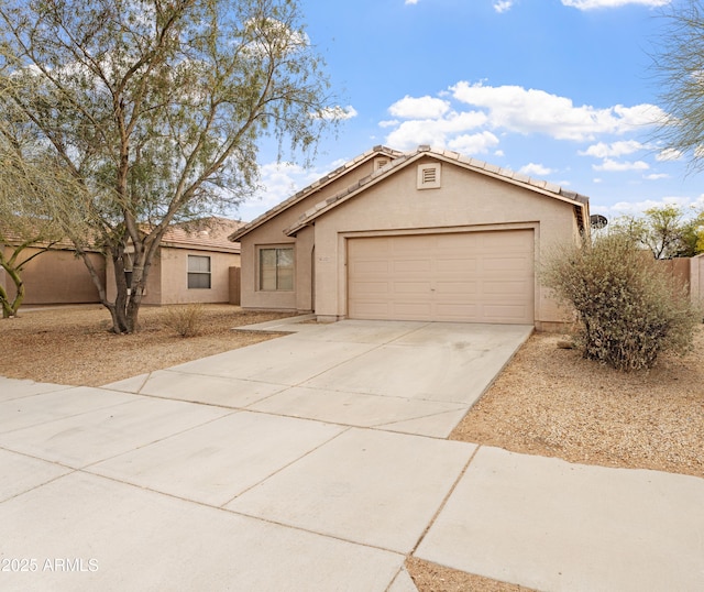 view of front facade with stucco siding, an attached garage, a tile roof, and driveway