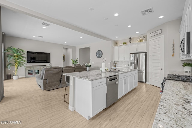 2343 E Kelly Dr, Gilbert, AZ 85298 - kitchen with appliances with stainless steel finishes, a sink, a center island with sink, white cabinets, and light wood-style floors