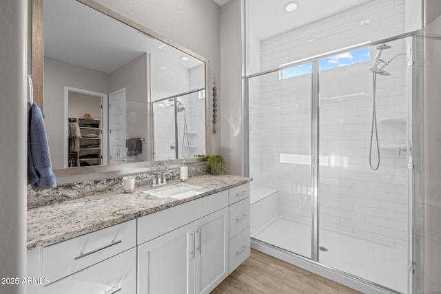 2343 E Kelly Dr, Gilbert, AZ 85298 - bathroom featuring a shower stall, a spacious closet, vanity, and wood finished floors