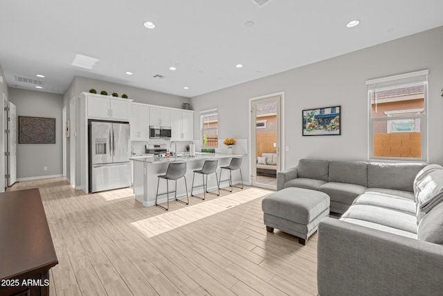 2343 E Kelly Dr, Gilbert, AZ 85298 - living area featuring healthy amount of natural light, recessed lighting, light wood-style floors, and baseboards