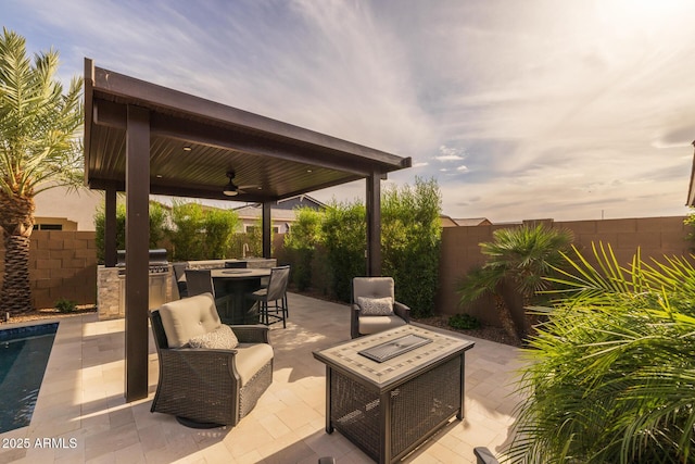 2343 E Kelly Dr, Gilbert, AZ 85298 - fenced backyard with an outdoor kitchen, ceiling fan, a patio area, an outdoor living space with a fire pit, and outdoor dining area