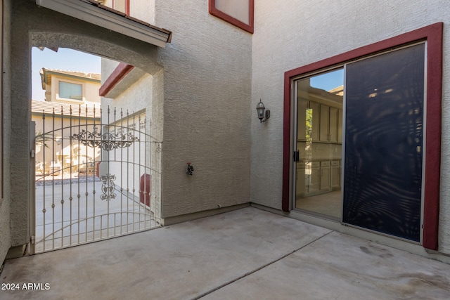 property entrance featuring a patio area, a gate, and stucco siding