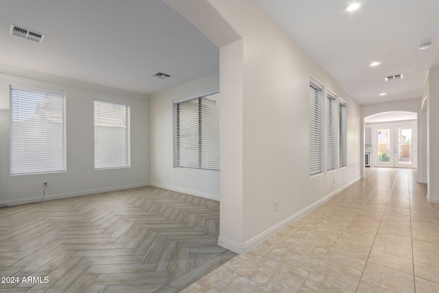 hallway featuring arched walkways, baseboards, visible vents, and recessed lighting