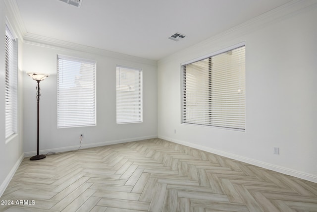 spare room with ornamental molding, visible vents, and baseboards