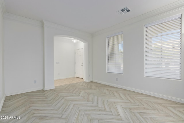 unfurnished room with arched walkways, ornamental molding, visible vents, and baseboards