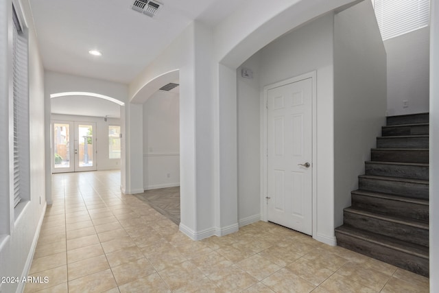 interior space with light tile patterned flooring and french doors