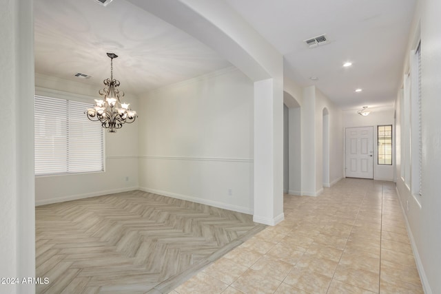 interior space with light tile patterned floors, an inviting chandelier, and crown molding