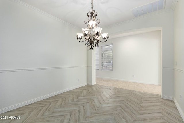 spare room with light parquet floors, a chandelier, and ornamental molding