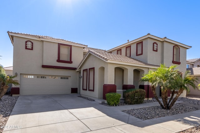 mediterranean / spanish-style house featuring a tile roof, driveway, an attached garage, and stucco siding