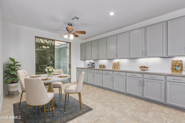 kitchen with light tile patterned floors, tasteful backsplash, ceiling fan, and gray cabinetry