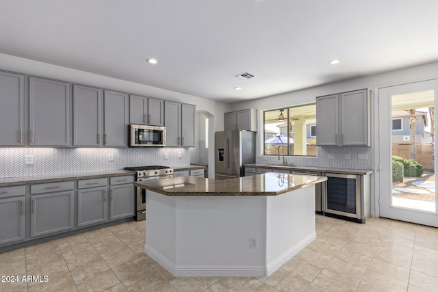 kitchen with appliances with stainless steel finishes, wine cooler, gray cabinets, and visible vents