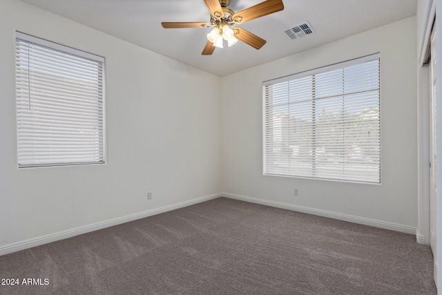 spare room featuring ceiling fan, carpet, visible vents, and baseboards