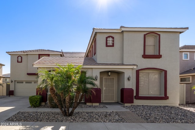 view of front of home featuring a garage, concrete driveway, and stucco siding