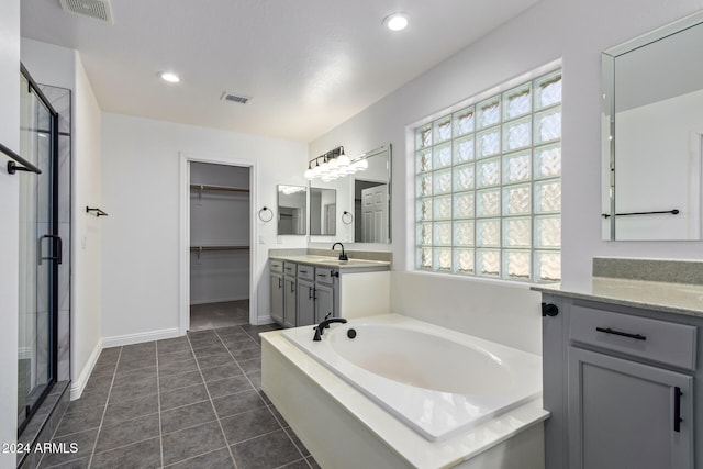 bathroom with tile patterned flooring, vanity, and plus walk in shower