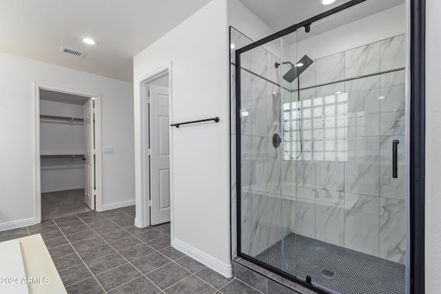 full bathroom featuring tile patterned flooring, visible vents, baseboards, a spacious closet, and a shower stall