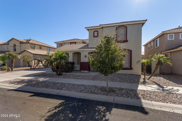 mediterranean / spanish-style house with driveway, a tile roof, and stucco siding