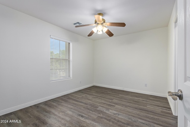 spare room with ceiling fan, dark wood-type flooring, visible vents, and baseboards