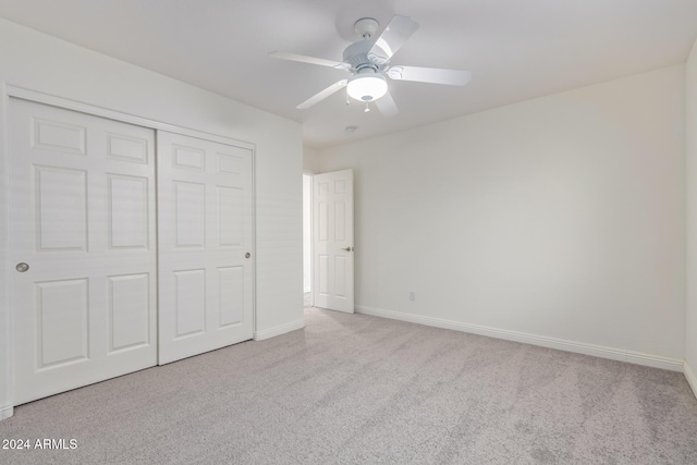 unfurnished bedroom with ceiling fan, a closet, and light carpet