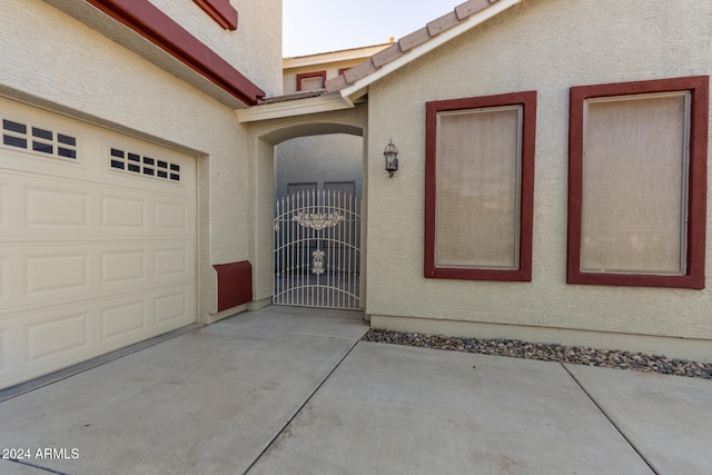 garage featuring driveway and a gate