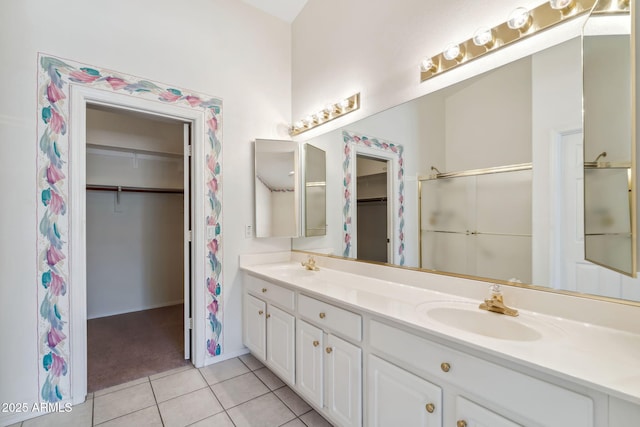 8426 W Utopia Rd, Peoria, AZ 85382 - bathroom featuring a walk in closet, double vanity, tile patterned flooring, a shower, and baseboards