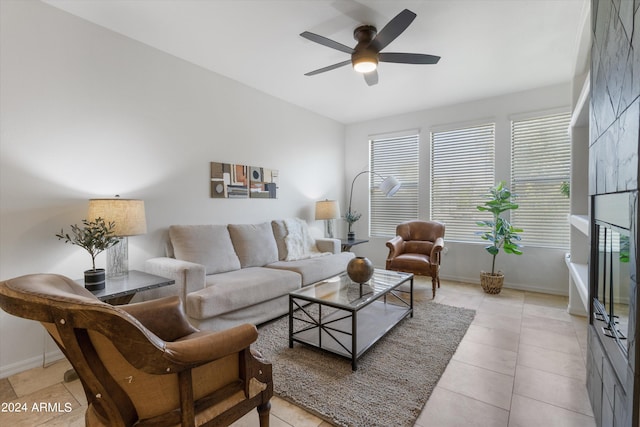 living room with a large fireplace, ceiling fan, and light tile patterned flooring