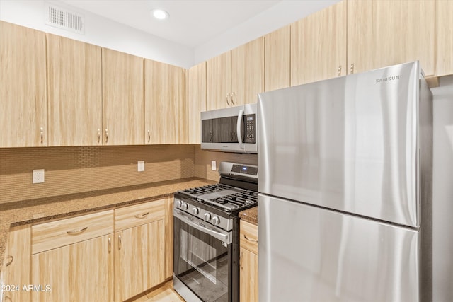 kitchen featuring tasteful backsplash, appliances with stainless steel finishes, light brown cabinetry, and stone counters