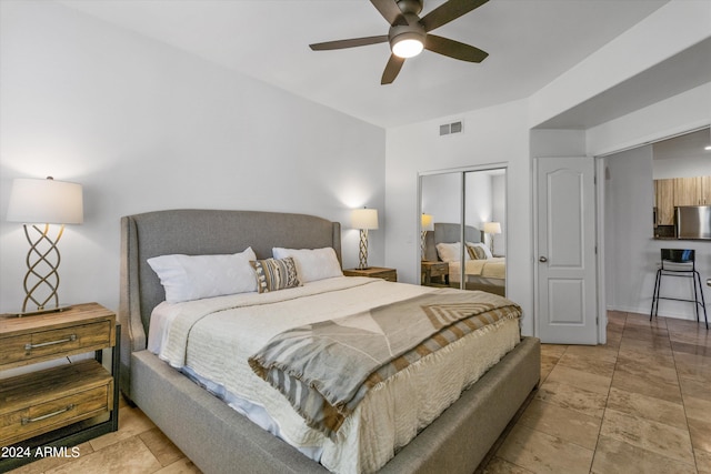 bedroom with fridge, ceiling fan, and a closet