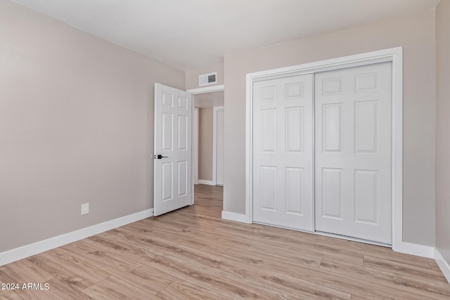 unfurnished bedroom with light hardwood / wood-style floors and a closet